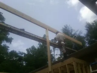 Carpenter setting a ridge beam over a new addition frame — Ice Dam Removal by Roofing Brothers in Lakeville